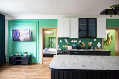 a kitchen with green walls and a counter top at Jungle apartment in the center in Sofia