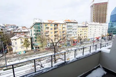 a balcony with a view of a city in the snow at Jungle apartment in the center in Sofia