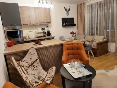a kitchen and living room with chairs and a table at BH and Semiramida Ski Apartment in Borovets