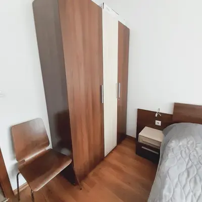 a bedroom with a bed and a chair and a closet at Апартамент В204 Belvedere Holiday Club in Bansko