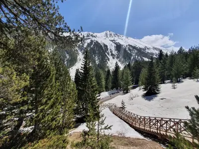 a snow covered mountain with a bridge in the foreground at Апартамент В204 Belvedere Holiday Club in Bansko