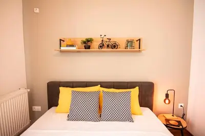 a bedroom with a bed with yellow and black pillows at Apartment with private parking 1 in Sofia