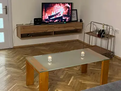 a living room with a table and a tv at The white suite in Sofia