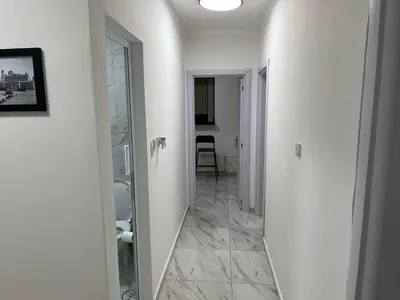 a hallway with a mirror and a toilet in a room at The white suite in Sofia