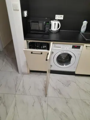 a kitchen with a washing machine and a microwave at The white suite in Sofia