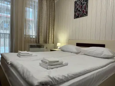a bedroom with a white bed with towels on it at Grand Monastery Private Apartment in Pamporovo in Pamporovo