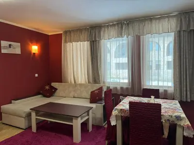 a living room with a couch and a table at Grand Monastery Private Apartment in Pamporovo in Pamporovo