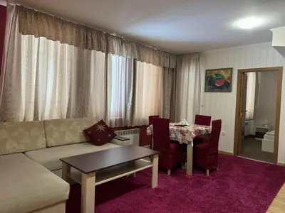 a living room with a couch and a table at Grand Monastery Private Apartment in Pamporovo in Pamporovo