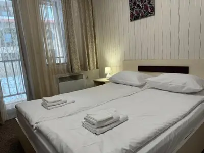 a bedroom with a white bed with towels on it at Grand Monastery Private Apartment in Pamporovo in Pamporovo