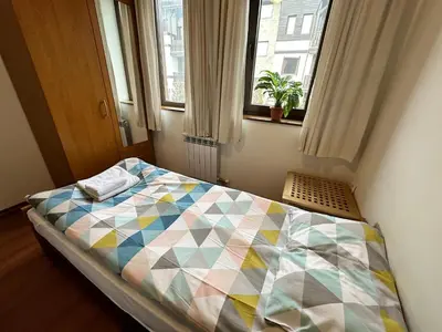 a bedroom with a bed with a colorful quilt on it at Gramadeto two bedroom apartment next to Gondola in Bansko