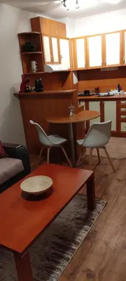 a living room with a couch and a table and chairs at Уютная квартира в комплексе Snow Lodge in Bansko