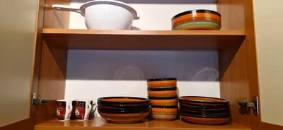 a wooden shelf with bowls and cups on it at Уютная квартира в комплексе Snow Lodge in Bansko