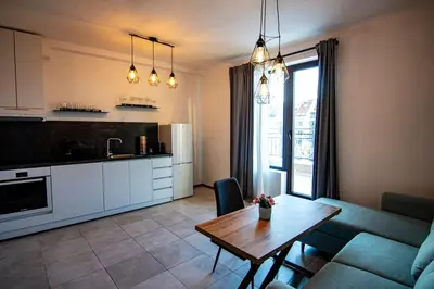 a kitchen and a living room with a table and a couch at Аpartment with Free Parking in Sofia