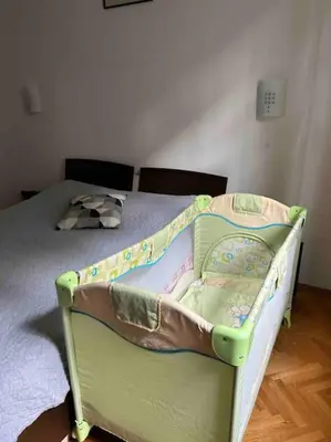 a baby crib in a bedroom with a bed at Casa del Rey in Sofia