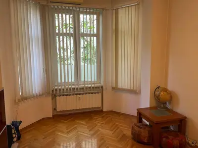 a living room with two large windows and a wooden floor at Casa del Rey in Sofia