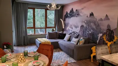 a living room with a couch and a painting on the wall at Pinewood ANG premium luxurious apartment 15 in Borovets