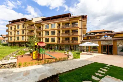 a large building with a playground in front of it at Pirin Sense apartment A11 in Bansko