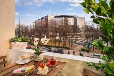 a balcony with a table with a view of a city at National Palace Of Culture 1 Step Away! in Sofia