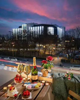 a table with a bottle of wine and wine glasses at National Palace Of Culture 1 Step Away! in Sofia