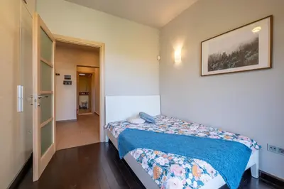 a small bedroom with a bed with a blue blanket at Modern yet Rustic Style City Centre Apt 2BR/2BTH in Sofia