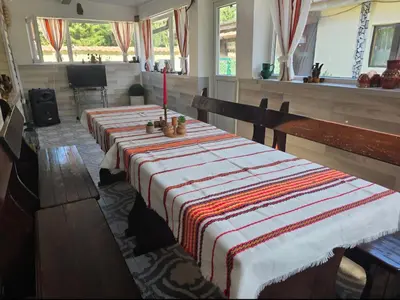 a dining room with two tables with a red candle on it at Guest House Freya in Beli Iskar