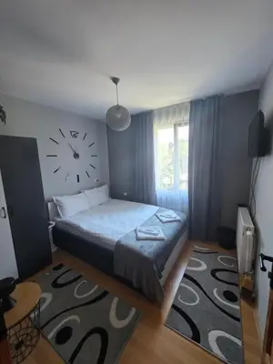 a bedroom with a bed with a clock on the wall at Guest House Freya in Beli Iskar