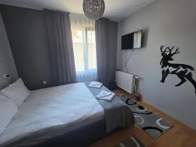 a bedroom with a bed with a deer on the wall at Guest House Freya in Beli Iskar