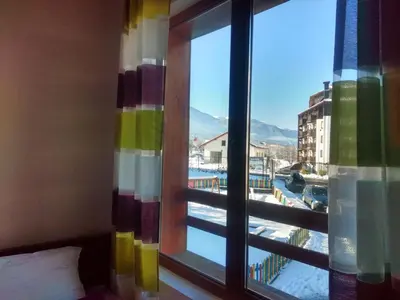 a room with a window with a view of a pool at TO FOUR+2 PREDELA 1 in Bansko