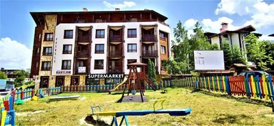 a building with a playground in front of a building at TO FOUR+2 PREDELA 1 in Bansko