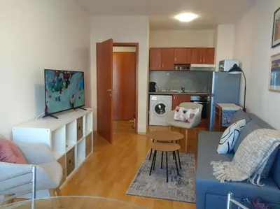 a living room with a blue couch and a kitchen at TO FOUR+2 PREDELA 1 in Bansko