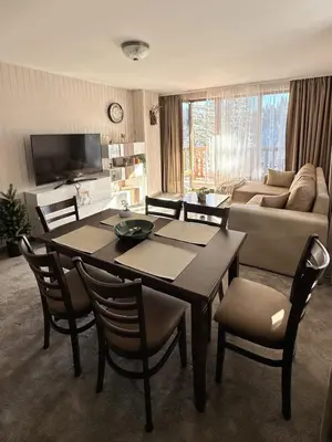 a living room with a table and chairs and a couch at ELEA Apartment Mountain Lodge Pamporovo in Pamporovo