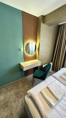 a hotel room with a bed and a mirror at ELEA Apartment Mountain Lodge Pamporovo in Pamporovo