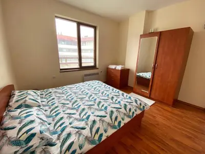 a bedroom with a bed and a dresser and a window at Cedar Heights Cozy Apartments in Pamporovo