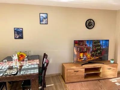 a dining room with a table and a television at IZ VIEW Apartment in Bansko