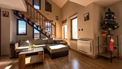 a living room with a couch and a christmas tree at IZ VIEW Apartment in Bansko