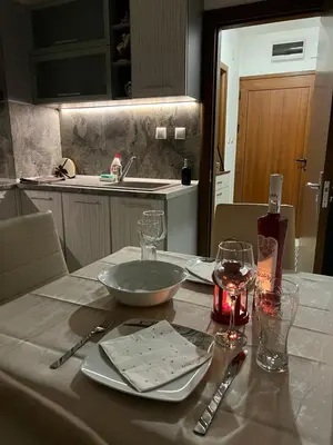 a table with a bowl and plates and glasses on it at Apartament Kamarashki in Troyan