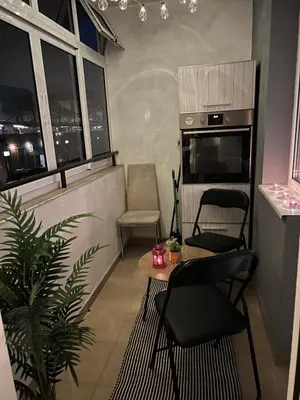 a living room with a table and chairs and windows at Apartament Kamarashki in Troyan