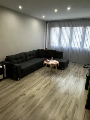 a living room with a black couch and a table at Апартамент Миели in Sofia