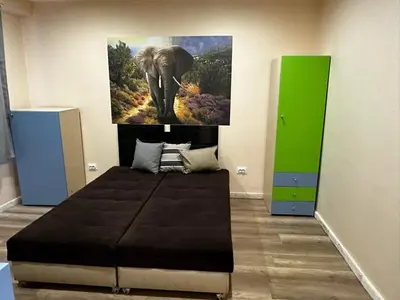 a bedroom with an elephant painting on the wall at Апартамент Миели in Sofia