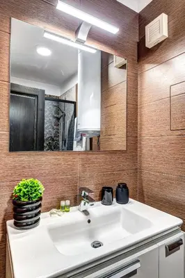 a bathroom with a white sink and a mirror at Boutique Apartment DOLCHE VITA in Smolyan
