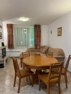 a living room with a wooden table and chairs at Скиелит 5 in Pamporovo