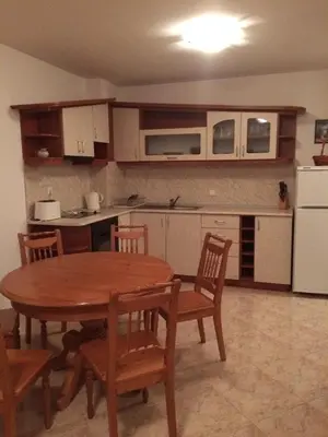 a kitchen with a wooden table and a table and chairs at Скиелит 5 in Pamporovo