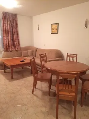 a living room with a couch and a table and chairs at Скиелит 5 in Pamporovo