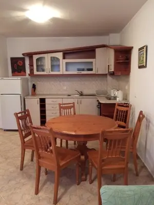 a kitchen with a wooden table and chairs in a kitchen at Скиелит 3 in Pamporovo