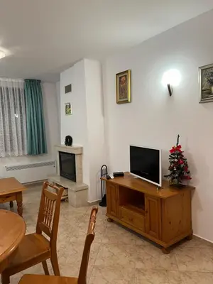 a living room with a television and a christmas tree at Скиелит 3 in Pamporovo