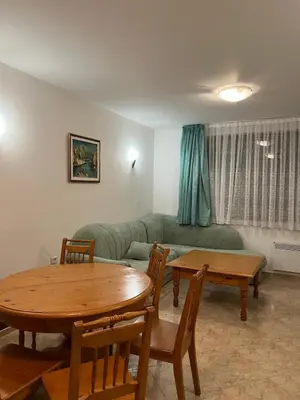 a living room with a table and a couch at Скиелит 3 in Pamporovo