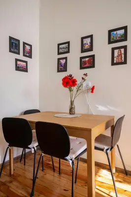 a dining room table with chairs and a vase with flowers at Stylish CityHub Retreat in Sofia Center by Flat Mаnager in Sofia