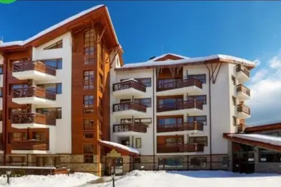 a apartment building with snow on the ground at Domo 12 Belmont, Bansko in Bansko