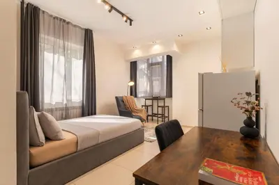 a bedroom with a bed and a table in a room at Victor Hugo Studio in Sofia