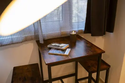 a wooden table with a candle and a book on it at Victor Hugo Studio in Sofia